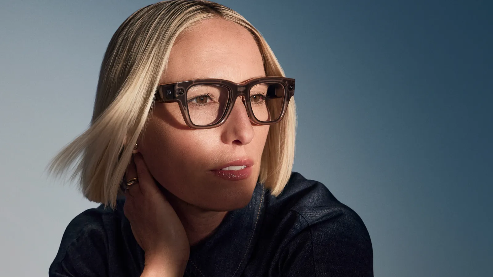 Model wearing Meta Ray-Ban Display smart glasses with neural band.